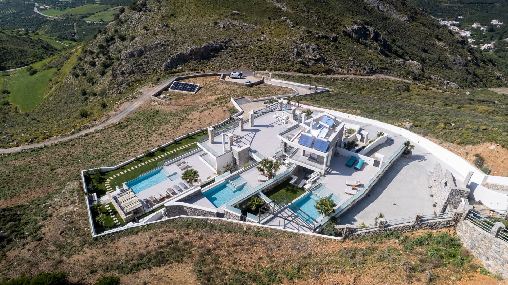 Drone hero shot of the full Secret Oasis compound and both villas above Plakias, South Crete