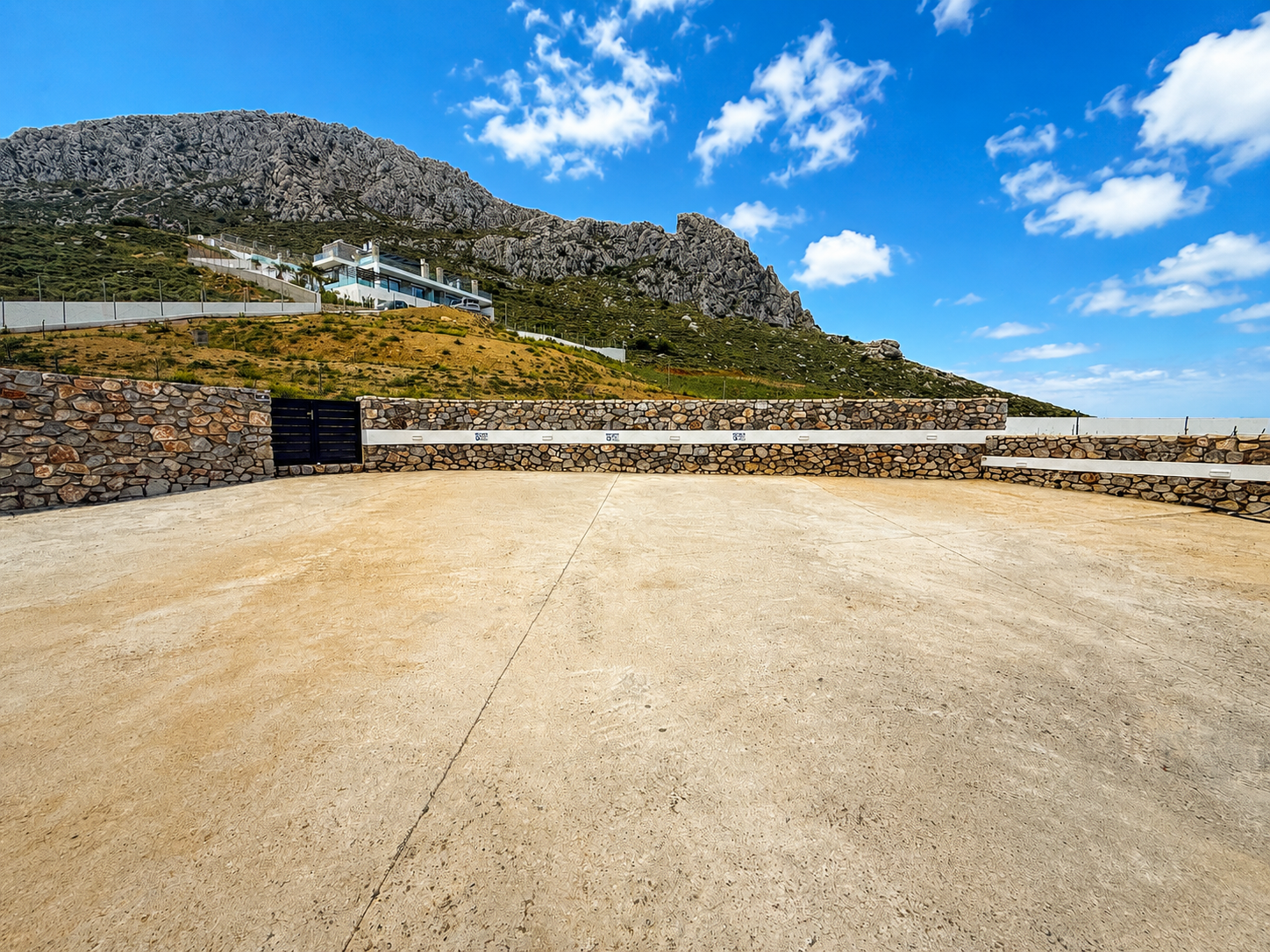 Shared parking area above Plakias for the Secret Oasis hill villas, with the estate on the ridge in the background