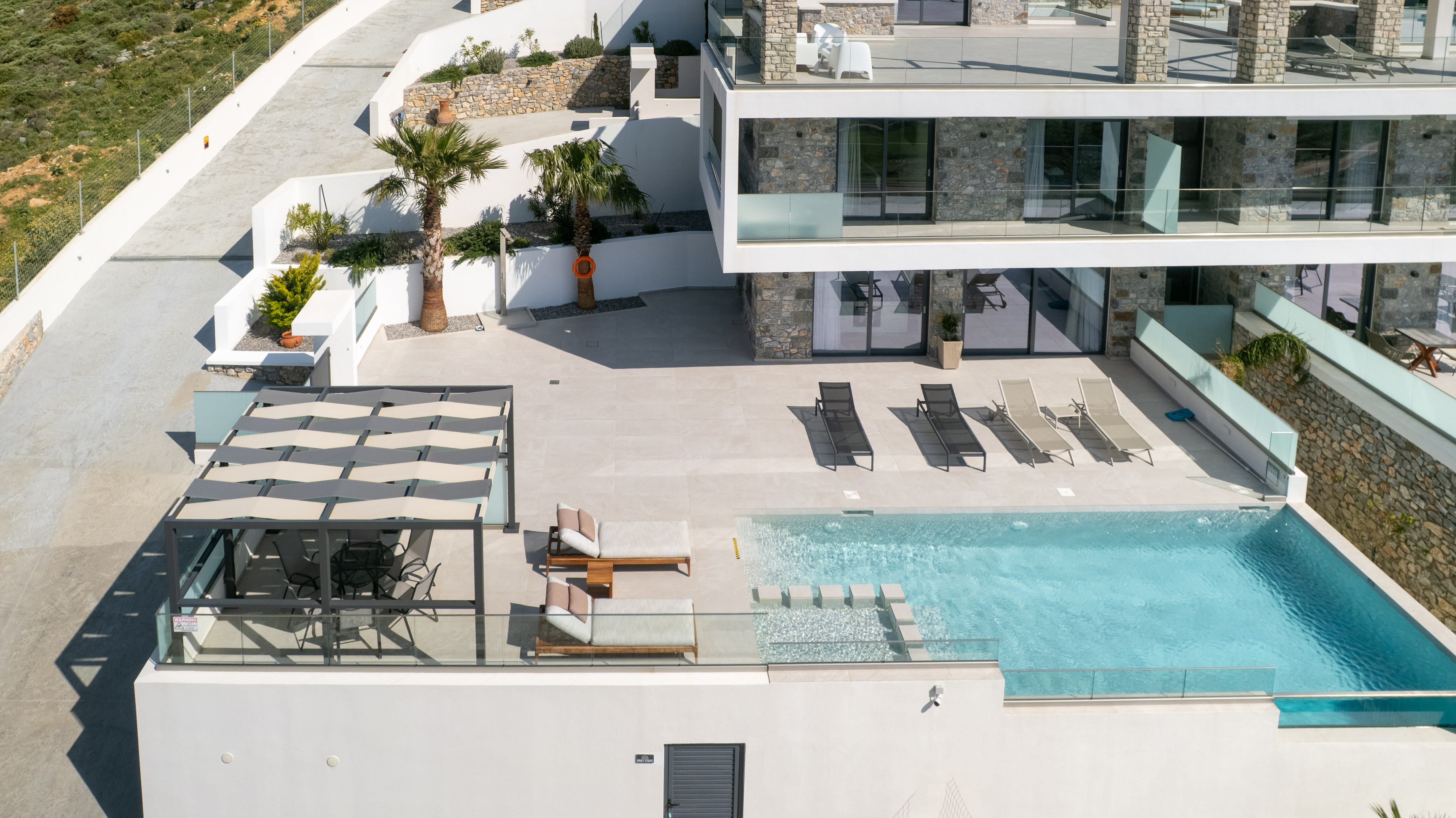 Villa with private pool in Plakias, Crete — Secret Oasis Villa 1 — drone view of pool terrace, infinity edge, pergola and palms